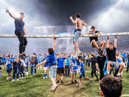 Los aficionados del Oviedo celebran sobre el césped del Carlos Tartiere la victoria sobre el Mirandés, que le permitió ascender a Primera División, el pasado 21 de junio.