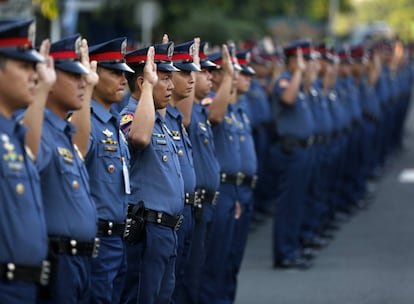 Varios miembros de la Policía Nacional de Filipinas se sitúan en formación frente a su sede en la ciudad de Quezón, al este de Manila, Filipinas.