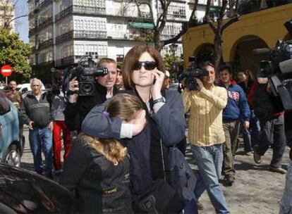 La menor que convivía con Miguel (con la cara tapada) sale de los Juzgados de Sevilla, ayer, tras prestar declaración.