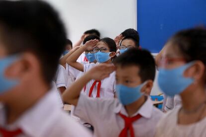 Alumnos escuchan el himno nacional, en una escuela de Phuc Dien, en Vietnam. Tras tres meses de parón por el coronavirus, la educación básica ha vuelto a las aulas en el país asiático.