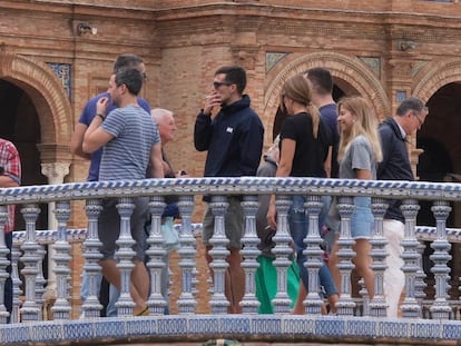 Un turista fuma en la Plaza de España de Sevilla.