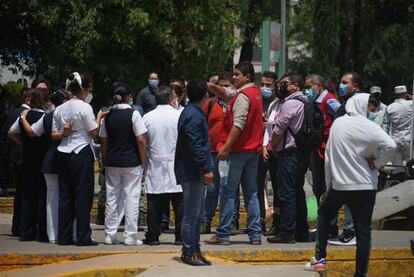 Personal sanitario del Hospital General de Atizapán se reúne a las afueras del edificio mientras prosigue la limpieza del centro. 