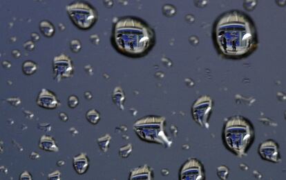 Gotas de lluvia que reflejan una pantalla que muestra información bursátil en Tokio (Japón).