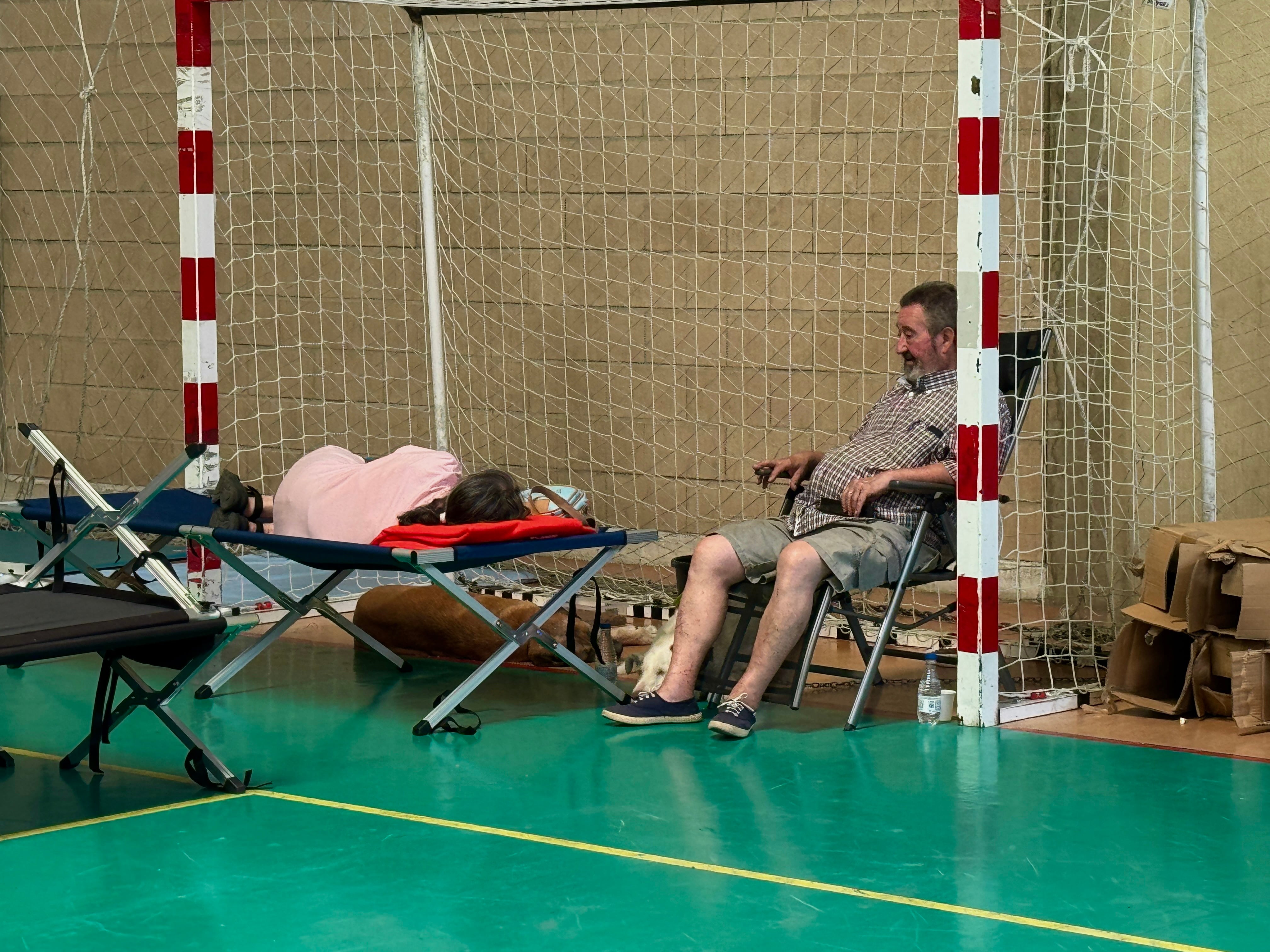 Personas desalojadas aguardan en el polideportivo de Cebreros, mientras esperan noticias sobre el avance del incendio.