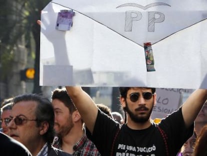 Un joven levanta un sobre con las siglas del PP en la manifestación contra la corrupción de este sábado.