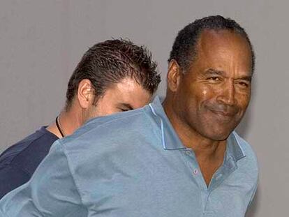 O. J. Simpson es conducido, esposado, tras su detención en Las Vegas por robo a mano armada.