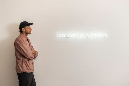 El artista brasileño Pedro Torres junto a parte de su díptico de neón titulado 'an observation, a version' (2022).