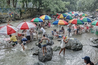 Familias en el balneario El Manantial del río Fula, en Bonao, durante un aguacero. 