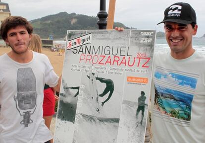 Los surfistas Ander Ugarte (izquierda) y Hodei Collazo posan ayer con el cartel del campeonato.
