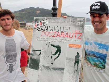 Los surfistas Ander Ugarte (izquierda) y Hodei Collazo posan ayer con el cartel del campeonato.