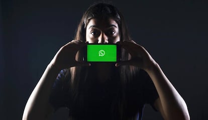Teléfono con WhatsApp delante de la boca