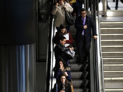 Varios viajeros del metro madrileño utilizan las escaleras mecánicas.