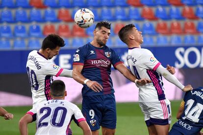 El delantero del Huesca Rafa Mir cabecea un balón entre Alcaraz y Óscar Plano este domingo en el partido ante el Valladolid en el estadio de El Alcoraz.