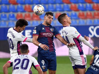 El delantero del Huesca Rafa Mir cabecea un balón entre Alcaraz y Óscar Plano este domingo en el partido ante el Valladolid en el estadio de El Alcoraz.