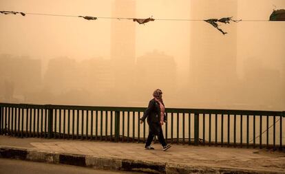 Varias personas caminan por las calles de El Cairo (Egipto) durante una tormenta de arena que ha cubierto parte de Oriente Medio.