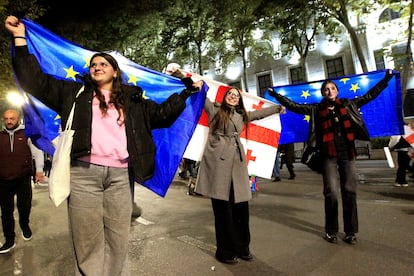 Unas manifestantes portan banderas georgianas y de la Unión Europea, durante las protestas por los resultados electorales, este lunes en Tbilisi.