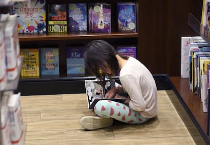 Una niña lee en el aeropuerto de Denver (Colorado) 