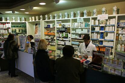 Empleadas de una farmacia de Barcelona dispensan medicinas a varias clientas.