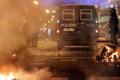 Restos de contenedores ardiendo en la Puerta del Sol, donde se desplegó la Policía antidisturbios.