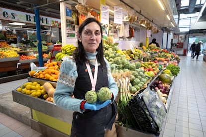 Paqui sostiene alcachofas en el puesto de frutas y verduras de FresCamp del Mercado Central de Benicarl, en una imagen de la pasada semana.