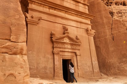 Una periodista hace una foto desde la entrada de una de las tumbas talladas en piedra arenisca en Madain Saleh (Arabia Saudí).