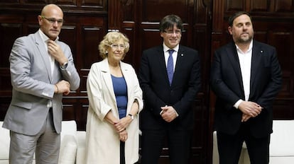 La alcaldesa de Madrid, Manuela Carmena, el presidente de la Generalitat Carles Puigdemont (2d), el vicepresidente catalán, Oriol Junqueras (d), el conseller de Asuntos Exteriores, Relaciones Institucionales y Transparencia, Raül Romeva, durante el encuentro mantenido esta tarde en el consistorio madrileño.