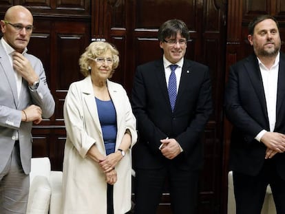 La alcaldesa de Madrid, Manuela Carmena, el presidente de la Generalitat Carles Puigdemont (2d), el vicepresidente catal&aacute;n, Oriol Junqueras (d), el conseller de Asuntos Exteriores, Relaciones Institucionales y Transparencia, Ra&uuml;l Romeva, durante el encuentro mantenido esta tarde en el consistorio madrile&ntilde;o.