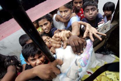 Un grupo de damnificados por el seísmo intenta acceder a la ayuda humanitaria en la localidad de Matara, al sur de Colombo, capital de Sri Lanka.