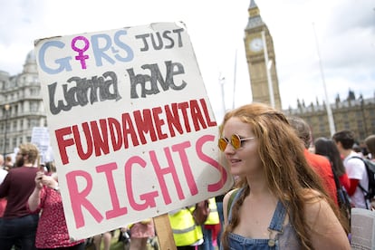 Una manifestante londinense sostiene una pancarta que rinde tributo a la canción de Lauper en una marcha feminista.