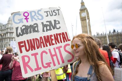 Una manifestante londinense sostiene una pancarta que rinde tributo a la canción de Lauper en una marcha feminista.
