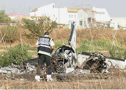 Un policía inspeccionaba ayer los restos del avión siniestrado cerca de la barriada sevillana de Valdezorras.