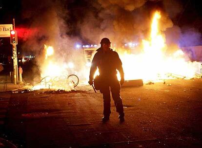 Un agente, ante la barricada de fuego que prendieron ayer los jóvenes en Copenhague