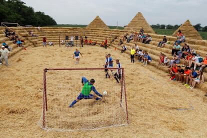 Aficionados participan en Rusia en un torneo local de fútbol celebrado en un estadio de paja, el pasado 22 de julio.