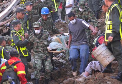 Soldados y residentes sacan un cadáver de los escombros en la localidad de Bello, al noroeste de Colombia.