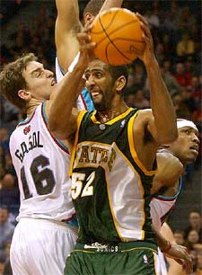 El jugador de los SuperSonics Booth lucha con Gasol por un balón.