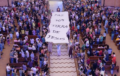 Actores sostienen una pancarta que dice "Paz en la Tierra de Jesús", durante la realización la "Pasión de Jesús" durante la Semana Santa en Brasil.