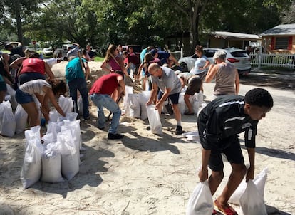 Un grupo de vecinos de la localidad de St. Petersburg (Florida) rellenan bolsas con tierra ante la llegada del huracán Irma.
