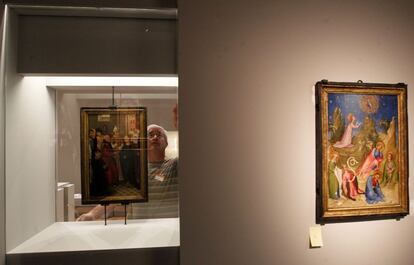 Un operario trabaja en el montaje de la exposición. A la derecha el cuadro anónimo, La Oración en el huerto con el donante Luis I de Orleans (1400-1407)