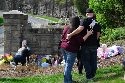 People gather at an entry to Covenant School which has become a memorial for shooting victims, Tuesday, March 28, 2023, in Nashville, Tennessee