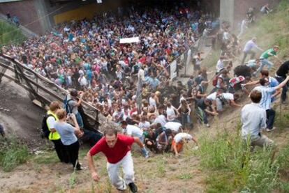 Asistentes al festival intentan huir de la aglomeración que se produjo en el túnel de acceso al recinto.