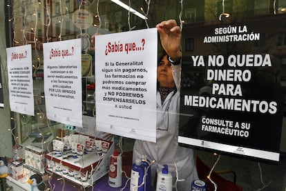 Una farmacéutica colocaba ayer carteles informativos en el escaparate de su oficina, en el centro de Valencia.