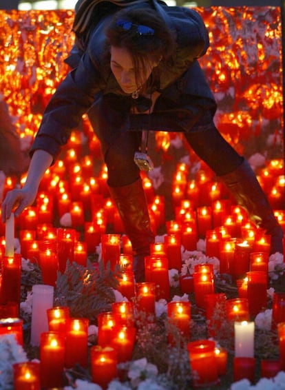 Una joven coloca una vela en el campus de la Universidad Complutense de Madrid, en un acto de homenaje a las víctimas mortales de los atentados de Al Qaeda del 11-M, el 22 de marzo de 2004.