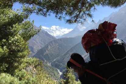 This April 6, 2016 photo shows a Nepali porter carrying his load north of the village of Namche Bazaar, Nepal. A trek to Everest Base Camp along mountain paths that hug deep gorges offers renewal and a test of mental and physical limits. Along the way there are sore knees and altitude sickness, but the spectacular landscapes, friendly villagers and moments of tranquility make the journey an unforgettable experience. (AP Photo/Karin Laub)