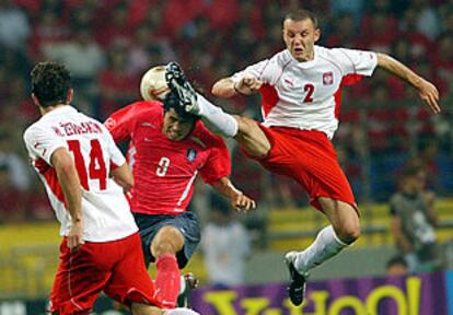 El polaco Klos le quita el balón de la cabeza al surcoreano Ki Hyeon Seol en una acción peligrosa.