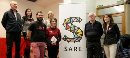 Los miembros de la Red Ciudadana Sare, con Joseba Azkarraga y Teresa Toda a la izquierda y derecha del logo de la organización