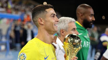 Al Nassr's Cristiano Ronaldo celebrates with the trophy after winning the Arab Club Champions Cup final.