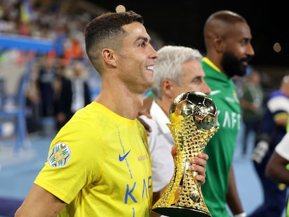 Al Nassr's Cristiano Ronaldo celebrates with the trophy after winning the Arab Club Champions Cup final.