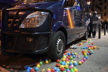 Pelotas de plástico junto a un furgón de la Policía Nacional.