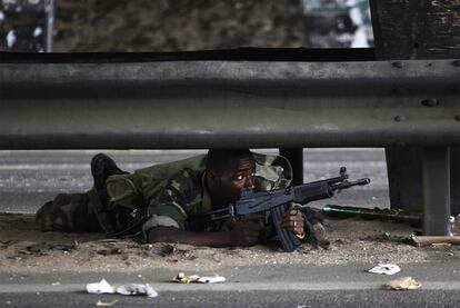 Un soldado leal al presidente electo Alassane Ouattara vigila una carretera en Abiyán.