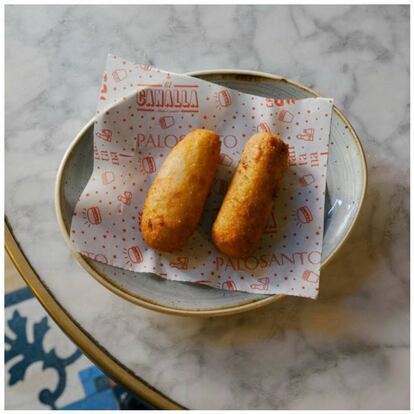 La Croqueta! (1,9 €, unidad). Así, con exclamación al final... y rellena de pollo que han guisado, previamente, al horno con mucha verdura (“para que quede jugoso y blandito”, nos informan). Los huesos del pollo se hierven junto a la leche. Un toque de curry y “mucho amor” hacen el resto.
<a href="http://gruposantelmo.com/es/restaurantes/palosanto">Palosanto. </a> Avinyó, 3. Barcelona.